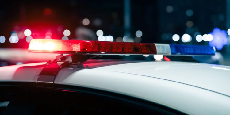 A close up view of flashing police lights on top of a car at night.