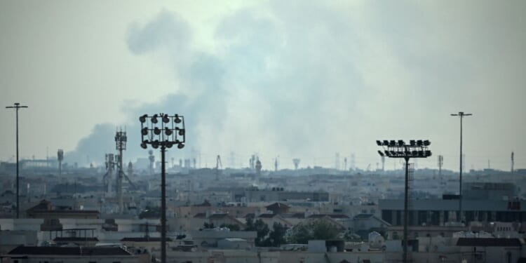 Smoke rises from an area in the direction of Al Udeid Air Base, which houses the Qatar Emiri Air Force and foreign forces including the United States, in Doha on Feb. 28, 2026, following a reported Iranian strike.