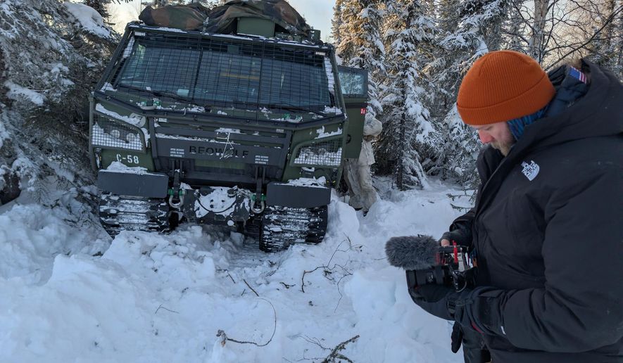 John T. Seward shoots photos and video in front of a Cold Weather All-Terrain Vehicle (CATV), known as Beowulf, during Joint Pacific Multinational Readiness Center Rotation 26-02.
