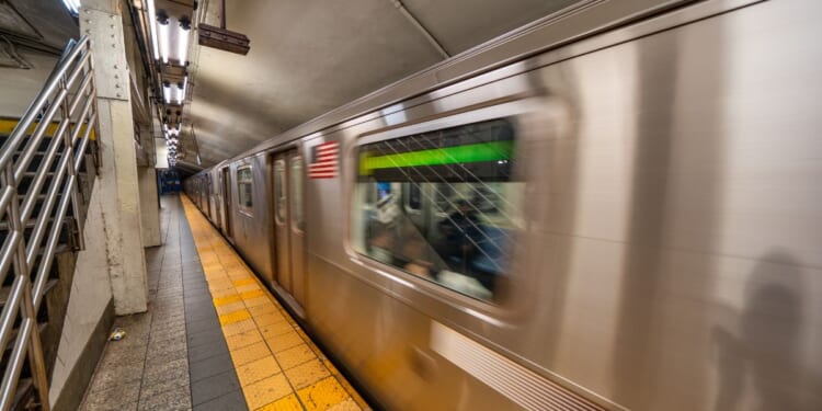 Subway train arriving at station in New York City underground transportation system.