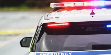 A stock photo of a police car with lights activated.