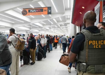 Ice agents look on Monday as travelers stand in long lines at Atlanta Hartsfield-Jackson International Airport in Atlanta, Georgia. The travel disruptions continue as hundreds of TSA agents quit or work without pay during a partial government shutdown. President Donald Trump said ICE agents will be deployed to U.S. airports, with border czar Tom Homan in charge of the effort.