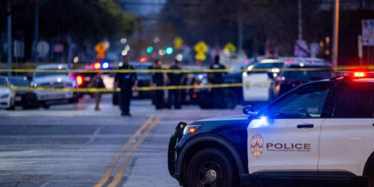 Police patrol the intersection near where three people were killed and 14 others hospitalized during a mass shooting at Buford's bar in downtown Austin, Texas, on March 1, 2026.