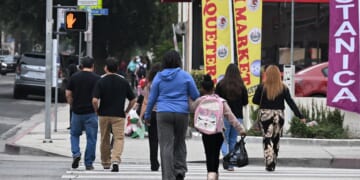 A student wearing a backpack crosses a street near Van Nuys Elementary School in the working class neighborhood Van Nuys of Los Angeles, California, on June 9, 2025.