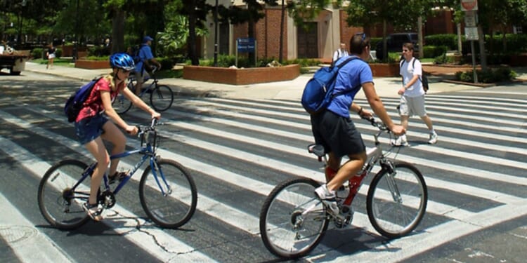 University of Florida students make their way through a crosswalk near the campus landmark Century Tower in Gainesville, Florida.