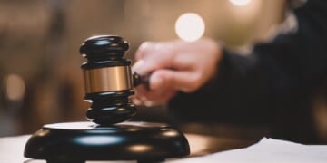 A judge's hand holding a gavel.