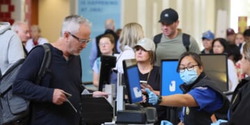 A traveler that does not have a Real ID is given a card stating he is not compliant at John Wayne Airport in Santa Ana, California, on May 7, 2025.