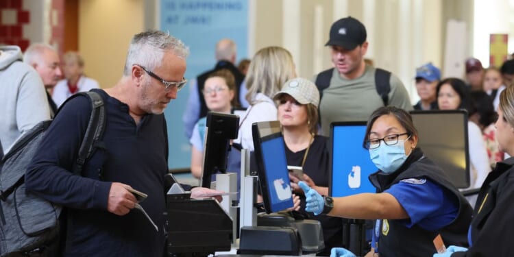 A traveler that does not have a Real ID is given a card stating he is not compliant at John Wayne Airport in Santa Ana, California, on May 7, 2025.