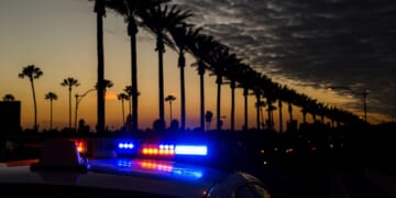 A police car goes by with lights activated on Gene Autry Way in Anaheim, California.