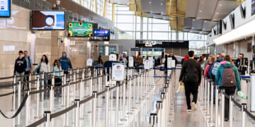 Travelers walk in the lines of Ronald Reagan International Airport on March 30, 2026.