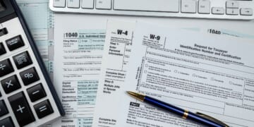 Blank tax forms sit on a desk.