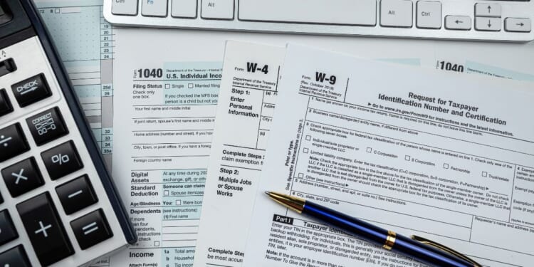 Blank tax forms sit on a desk.