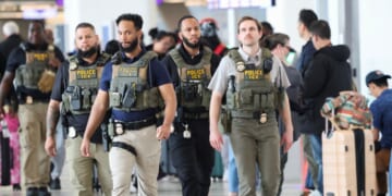 Federal law enforcement agents, including some with U.S. Immigration and Customs Enforcement, walk through LaGuardia Airport in New York on March 23, 2026.