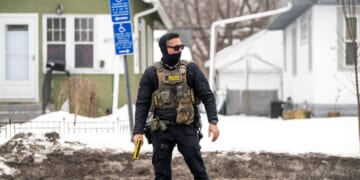 An ICE agent holds a taser as he stands watch after one of their vehicles got a flat tire on Penn Avenue on Feb. 5, 2026, in Minneapolis, Minnesota.