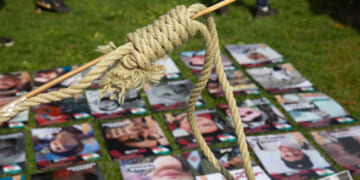 A woman holds a protest noose above photos of victims of Iranian executions on September 16, 2022.