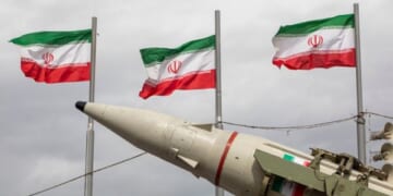 Iranian flags fly above missile during military demonstration in Tehran, Iran on Feb. 11, 2026.