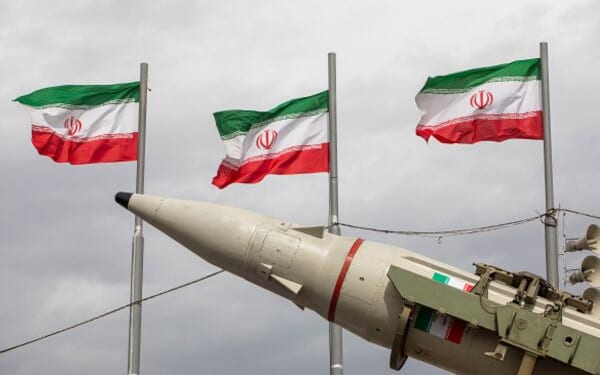 Iranian flags fly above missile during military demonstration in Tehran, Iran on Feb. 11, 2026.