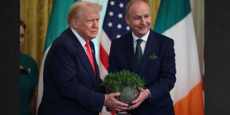 Irish Taoiseach (Prime Minister) Micheál Martin presents President Donald Trump with a bowl of clover during a 2025 St. Patrick’s Day event in the East Room of the White House in Washington, DC. Martin is once again scheduled to visit Trump at the White House next week.
