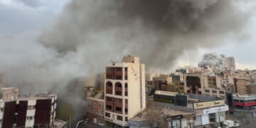 Plumes of smoke from two simultaneous strikes rise over Tehran, Iran, Monday. The attacks continued Tuesday with a reported strike on the city's airport.