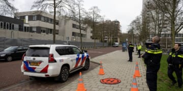 Police officers stand outside a Jewish school where an explosion was reported overnight in Amsterdam on March 14, 2026.
