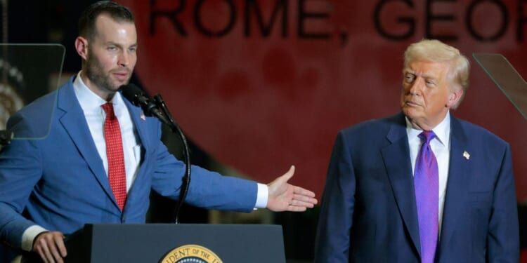 President Donald Trump, right, looks on Republican congressional candidate Clay Fuller speaks at the Coosa Steel Corporation in Rome, Georgia, on Feb. 19. Trump endorsed Fuller to replace the seat vacated by former Rep. Marjorie Taylor Greene.