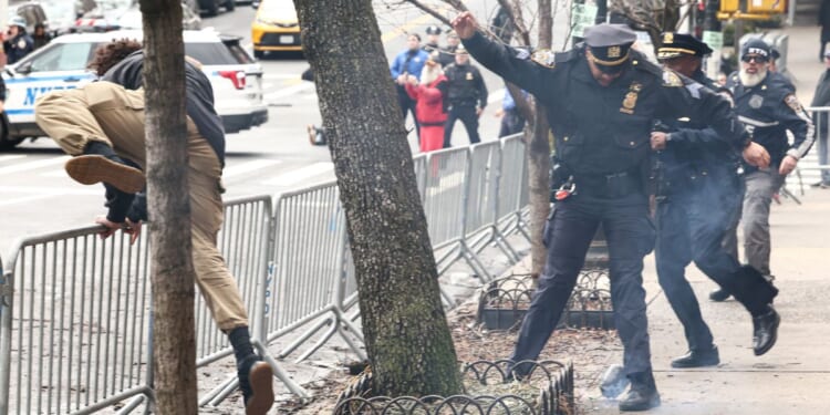 A left-wing activist flees the scene after throwing a homemade explosive device at anti-"Islamification" protesters in New York on March 7, 2026.