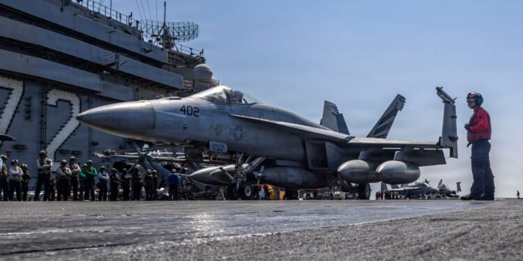 In this handout released by the U.S. Navy, an F/A-18E Super Hornet, attached to Strike Fighter Squadron (VFA) 151, taxis the flight deck of the Nimitz-class aircraft carrier USS Abraham Lincoln (CVN 72) in support of Operation Epic Fury on March 2, 2026.