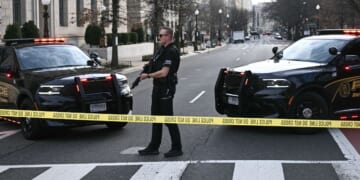 A member of the U.S. Secret Service patrols the scene where a van plowed into barricades near the White House in Washington, DC on March 11, 2026.