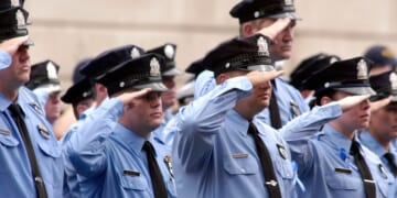 Philadelphia police officers salute as pallbearers carry the casket of Philadelphia Police Officer Gennaro Pellegrini Jr. to St. Anne's Church for a funeral mass on Aug. 20, 2005, in Philadelphia, Pennsylvania.