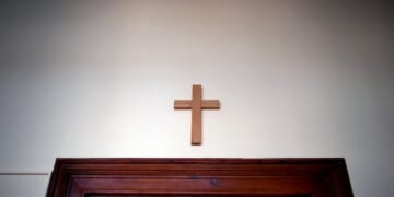 A wooden cross hangs over a door in an empty classroom at the Domgymnasium grammar school in Magdeburg, eastern Germany, on March 25, 2020.