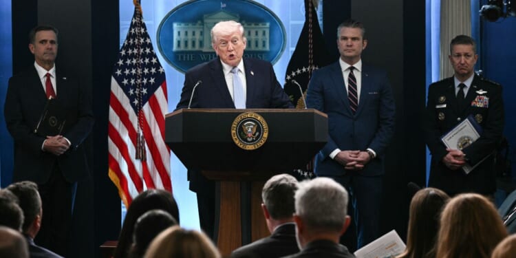President Donald Trump stands at a podium next to CIA Director John Ratcliffe, US Secretary of Defense Pete Hegseth, and Chairman of the Joint Chiefs of Staff General Dan Caine as he speaks about the Iran conflict in the James S. Brady Press Briefing Room of the White House in Washington, DC on April 6, 2026.