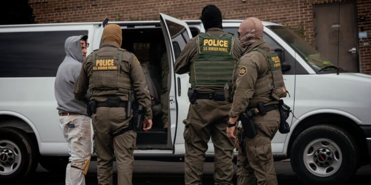 People detained earlier in the day are taken to a parking lot on the far north side of the city before being transferred to an Immigration and Customs Enforcement facility on Oct. 31, 2025, in Chicago, Illinois.