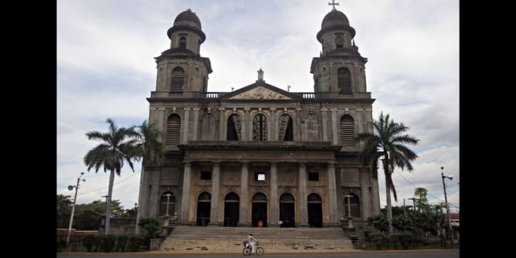 A man rides his bike in front of an old cathedral in Managua, Nicaragua on Oct. 19, 2009.