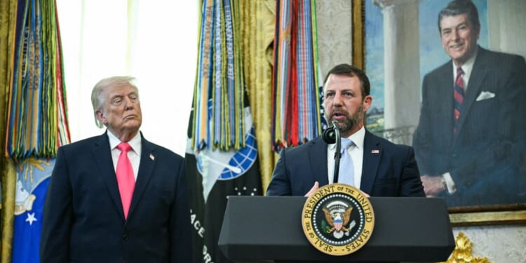President Donald Trump looks on as newly sworn in Secretary of Homeland Security Markwayne Mullin speaks in the Oval Office of the White House in Washington, D.C., on March 24, 2026.