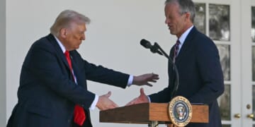 President Donald Trump shakes Senate Majority Leader John Thune's hand during an October event at outside the White House.