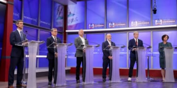 Six California gubernatorial candidates stand at podiums during a debate on April 22, 2026.