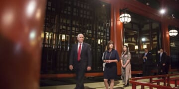 Mike Pence walks in Japan flanked by team members on April 18, 2017.