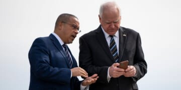 Minnesota Governor Tim Walz and Minnesota Attorney General Keith Ellison await the arrival of then-U.S. Vice President Kamala Harris at the Minneapolis-St. Paul International Airport in Saint Paul, Minnesota, on March 14, 2024.