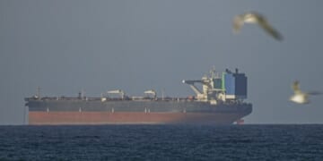 A ship waits to travel through the Strait of Hormuz in Oman on April 8, 2026.