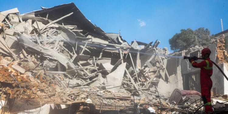 Emergency crews work at the site of a U.S.-Israeli strike Tuesday on what was described as a residential building adjacent to Rafi-Nia Synagogue in Tehran, Iran.