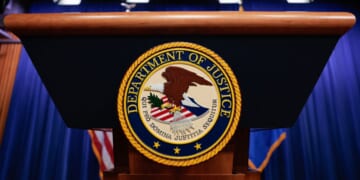 The seal of the Department of Justice sits on a podium in the Department of Justice headquarters in Washington, DC on April 7, 2026.