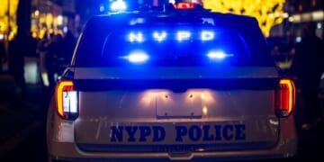A New York City Police Department night patrol car stops in traffic.