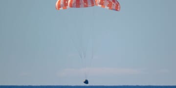 In this handout photo provided by NASA, NASA's Orion spacecraft with Artemis II crewmembers NASA astronauts Reid Wiseman, commander; Victor Glover, pilot; Christina Koch, mission specialist; and Canadian Space Agency astronaut Jeremy Hansen, mission specialist aboard is seen under parachutes as it lands in the Pacific Ocean off the coast of California on April 10, 2026.