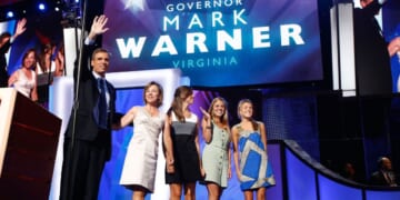 In a 2008 file photo, former Virginia Gov. Mark Warner waves from the stage with his wife, Lisa Collis, and daughters Eliza, Gillian, and Madison during day two of the Democratic National Convention in Denver, Colorado.