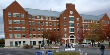 Students, parents, and others hold signs outside the Loudoun County school board meeting on Oct. 26, 2021, in Ashburn, Virginia.