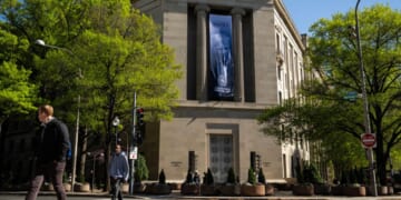 The Department of Justice stands with a poster of Donald Trump hanging from the pillars on April 7, 2026.
