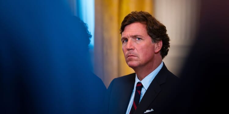 Former Fox News host Tucker Carlson looks on at a meeting with oil executives in the East Room of the White House on Jan. 8, 2026 in Washington, DC.