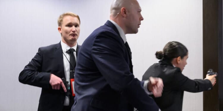 Agents draw their firearms after a shooting took place at the White House Correspondents' dinner at the Washington Hilton in Washington, DC on April 25, 2026.