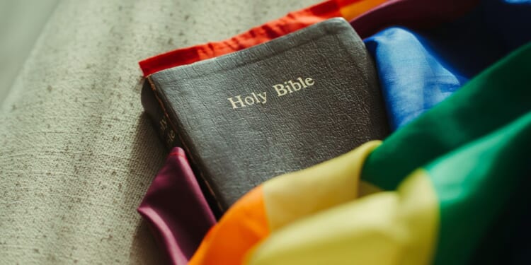 The Holy Bible wrapped in a rainbow-colored flag.