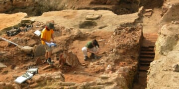 A stock photograph of two archeologists at work at a dig site.
